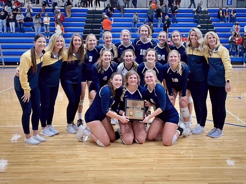 Volleyball team posing with trophy
