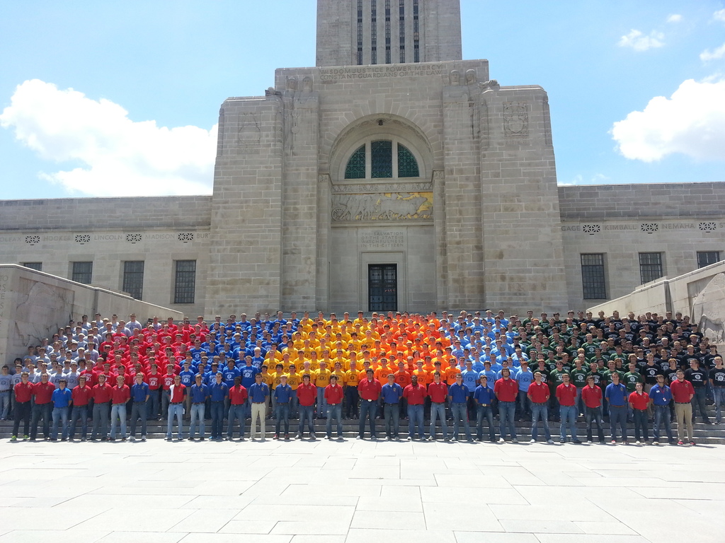 Students in rainbow colored shirts standing in front of the Nebraska capitol
